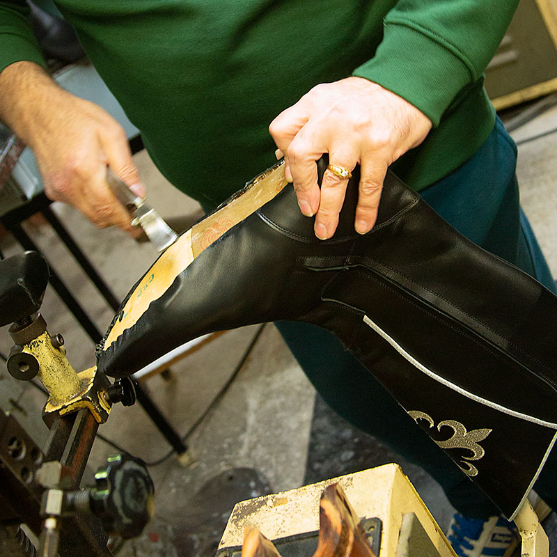 Manos de hombre trabajando en la fabricación de un zapato