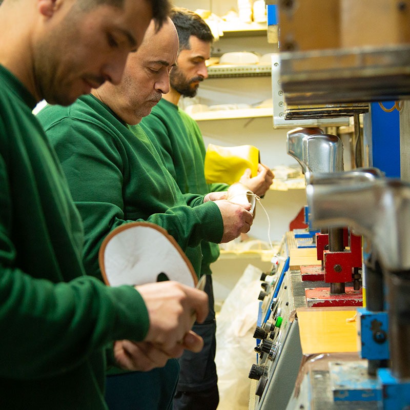Tres hombres trabajando en la fabricación de calzado
