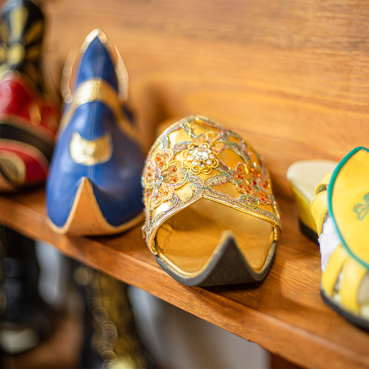 Varios zapatos de estilo moro sobre una estantería de madera