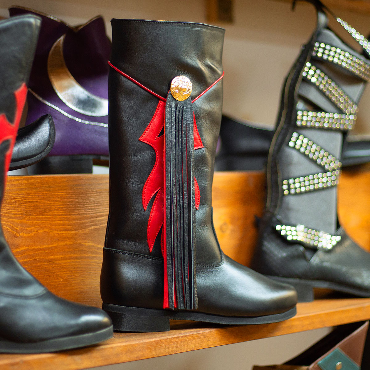 Varias botas de estilo cristiano sobre una estantería de madera