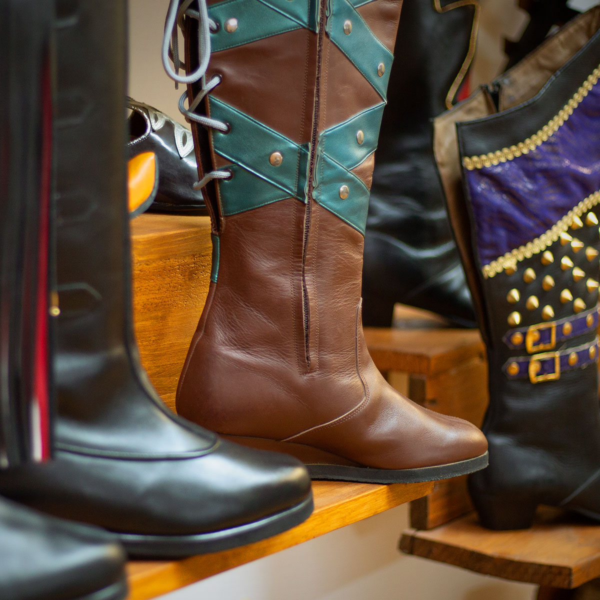 Varias botas para comparsas cristianas sobre una estantería de madera